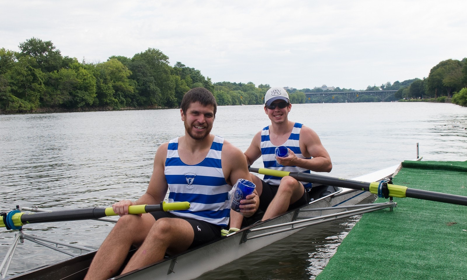 Two smiling rowers at the dock with their Quaker City mugs in 2015