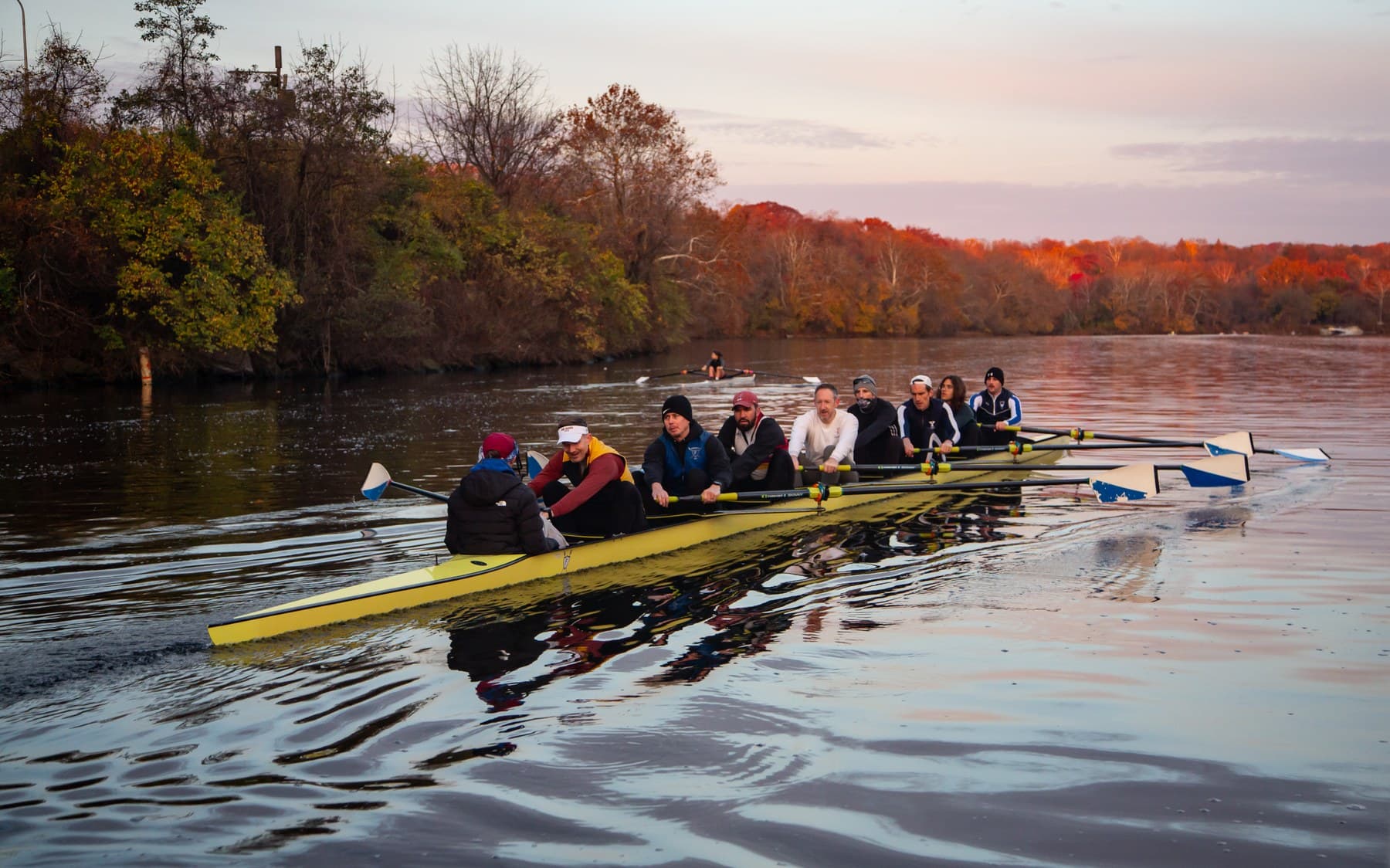 A Fairmount Masters eight rowing on the Schuylkill River in the fall