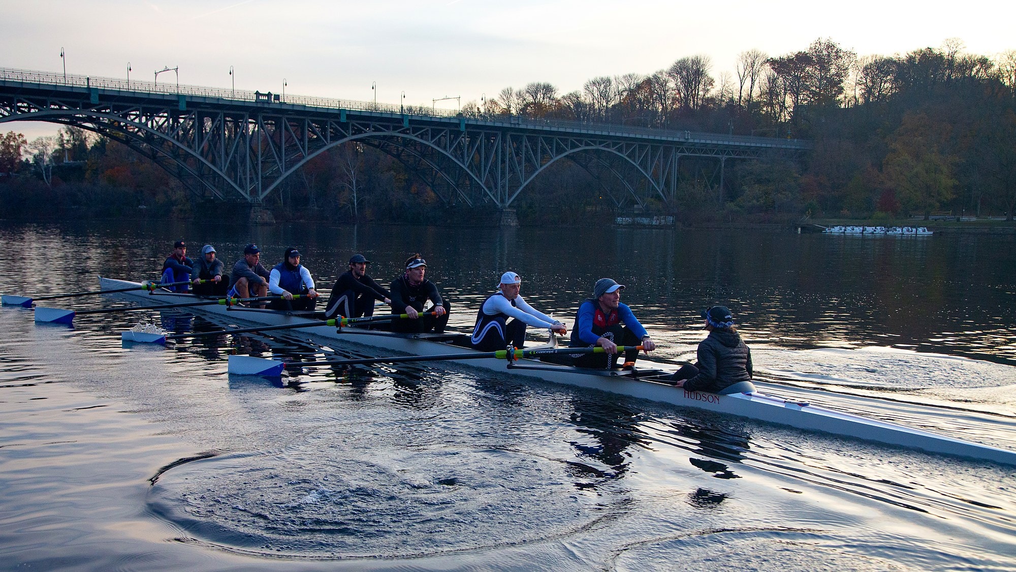 A Fairmount eight rowing below a steel bridge on the Schuylkill River